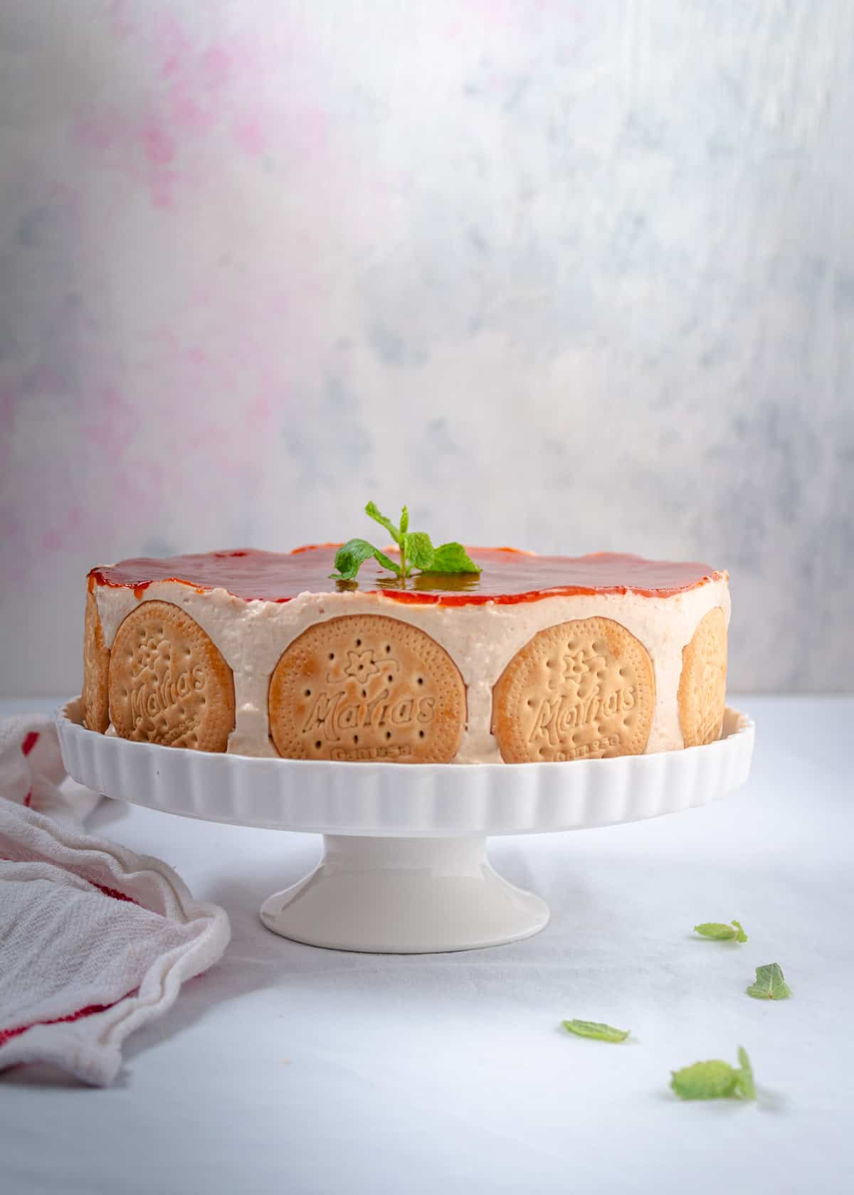 Mexican icebox cake with guava on a cake stand placed on a table.