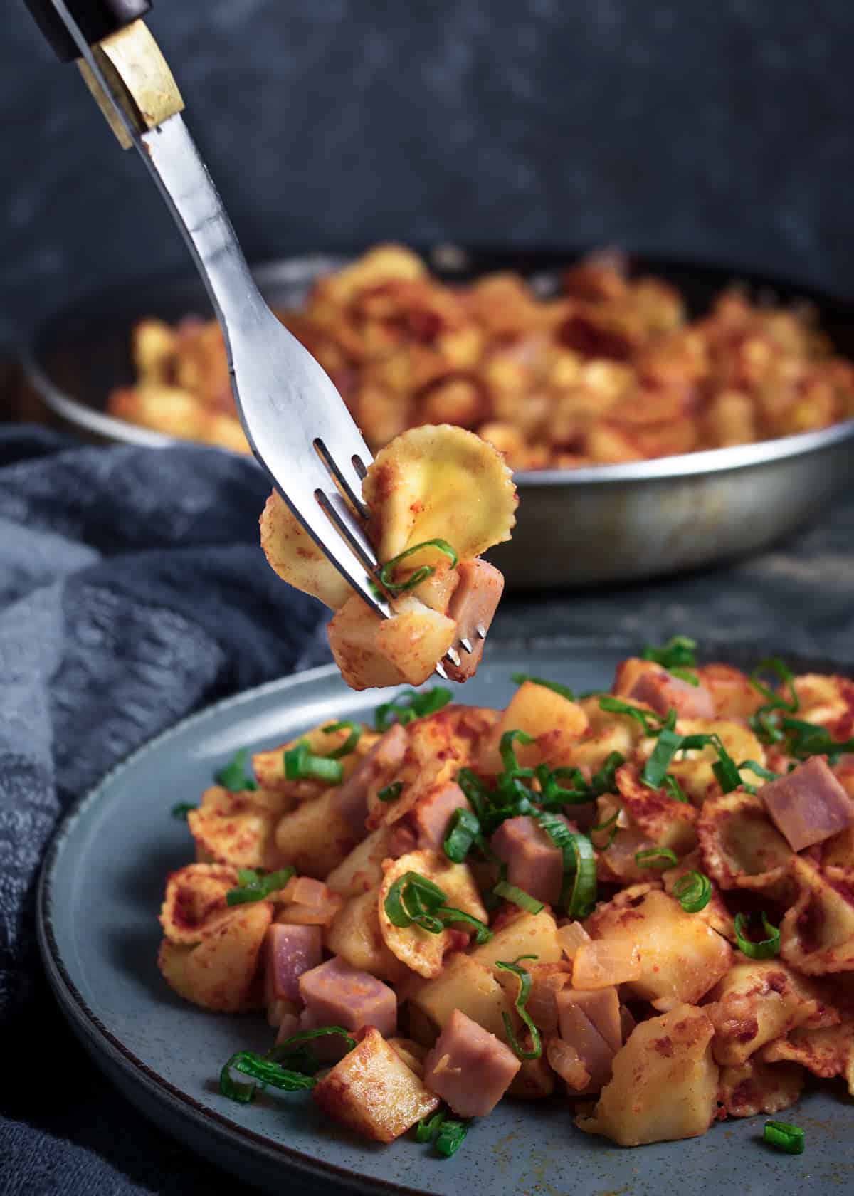 Potato pasta on a fork over a serving on a plate. 