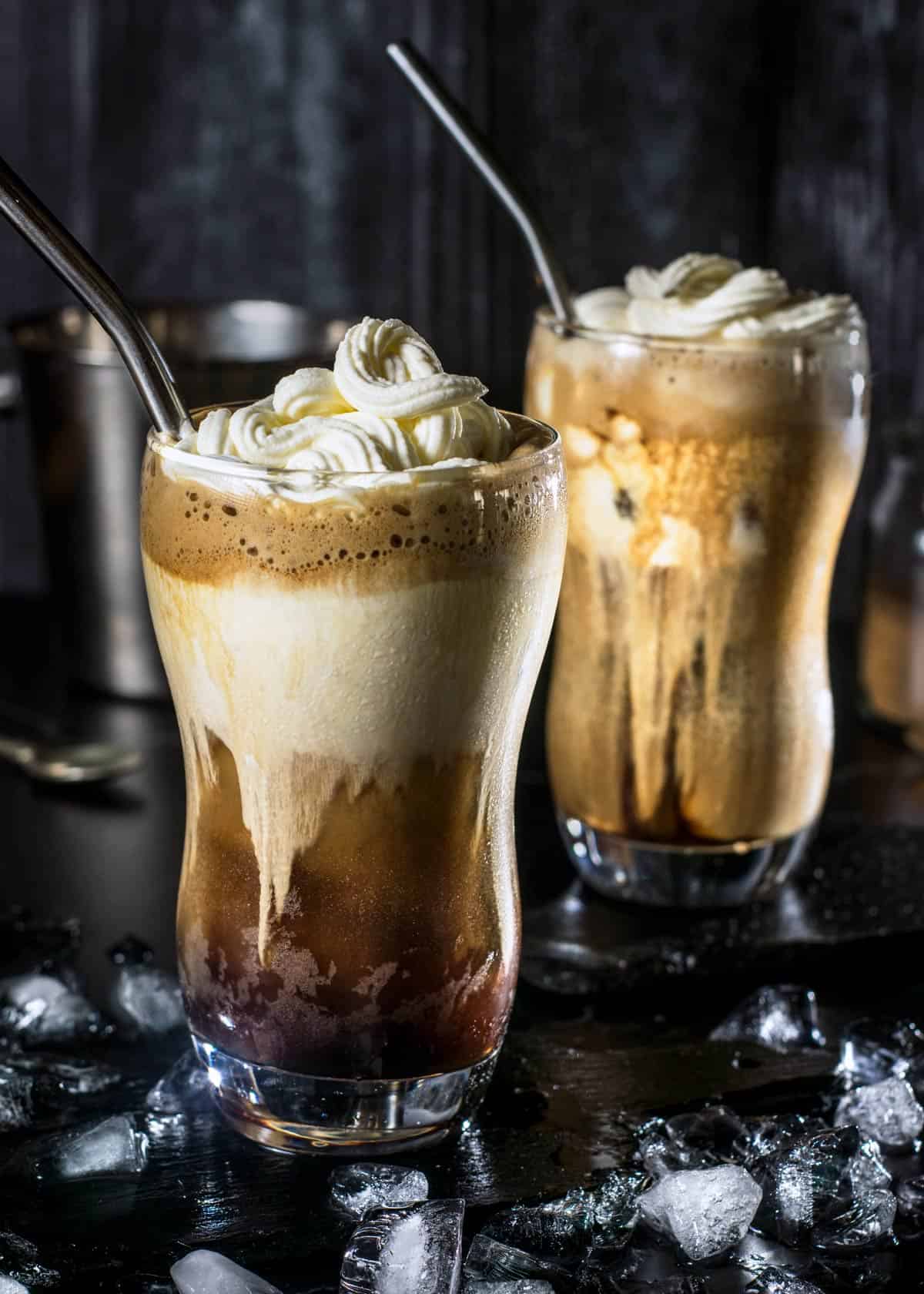 Greek-style iced coffee frappe served in two glasses with cream and whipped cream.