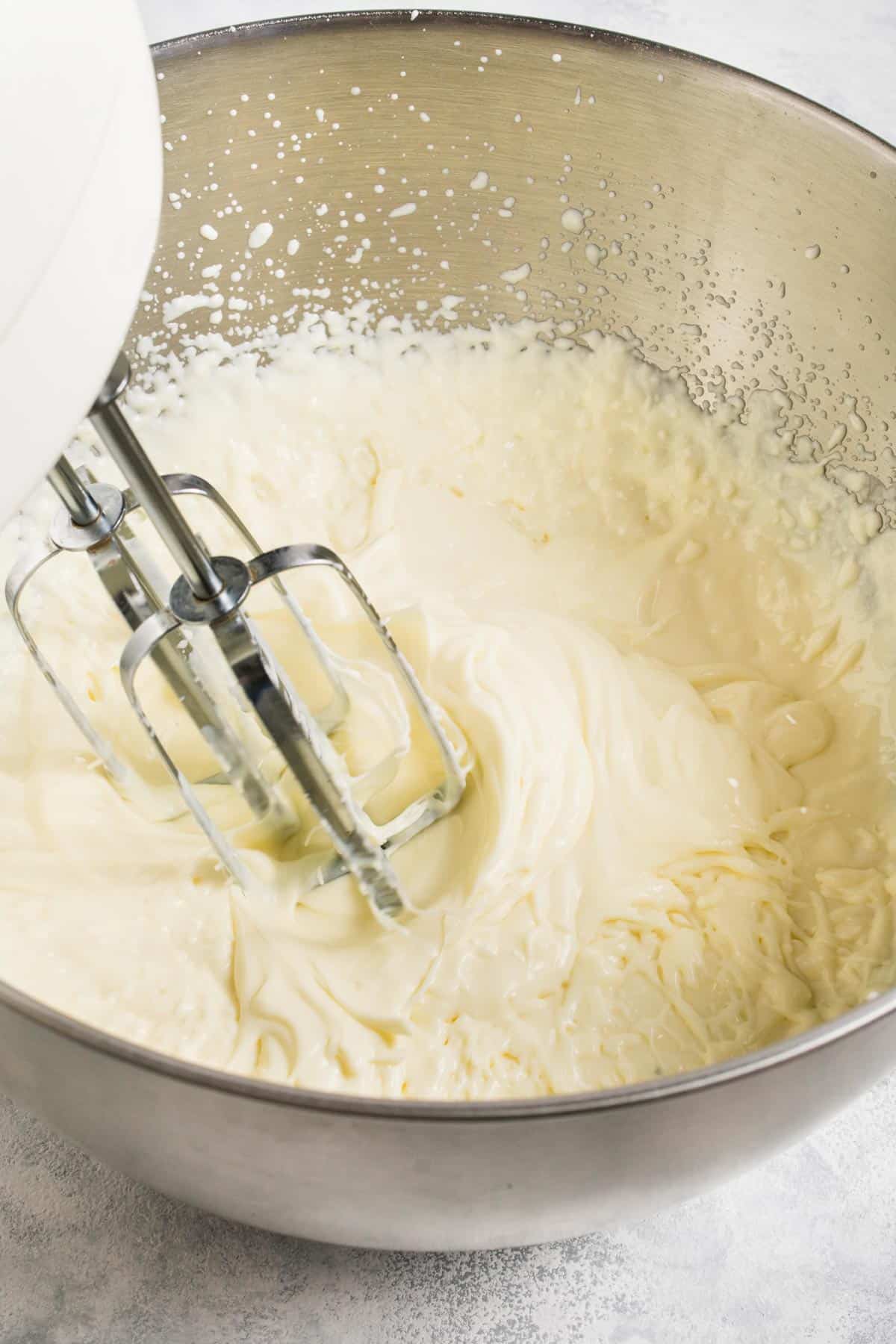 Whisking together margarita ice cream ingredients with an electric mixer. 