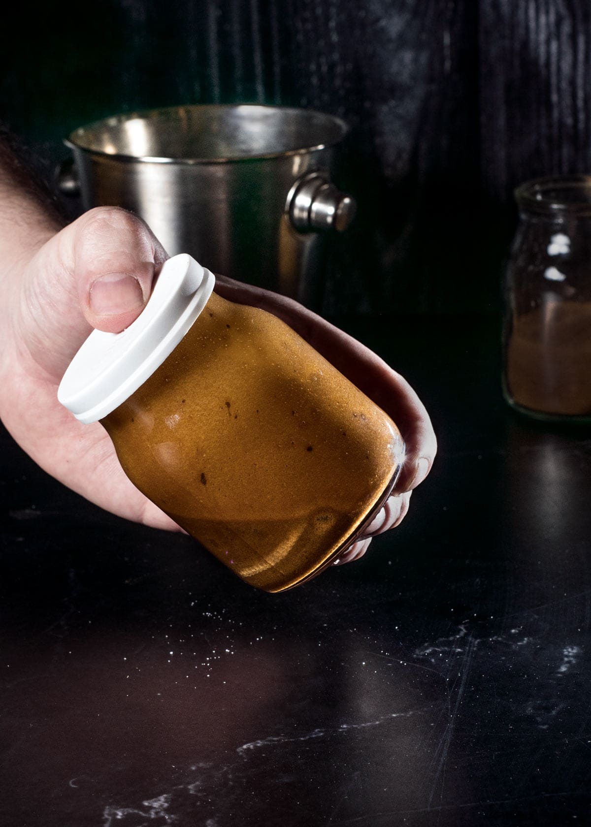 Shaking the instant coffee, sugar, and a bit of water in a closed jar to create foam.