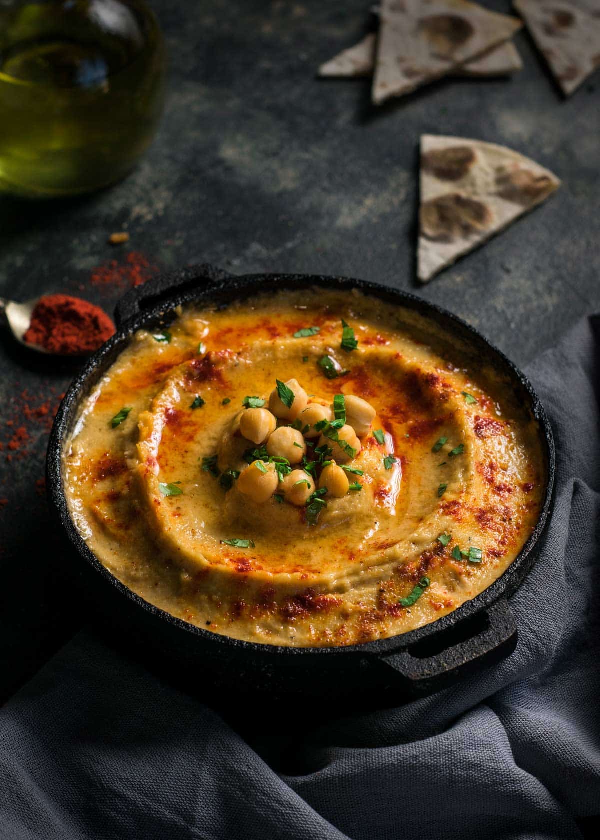 A small cast-iron dish with homemade Mediterranean dip topped with canned chickpeas.