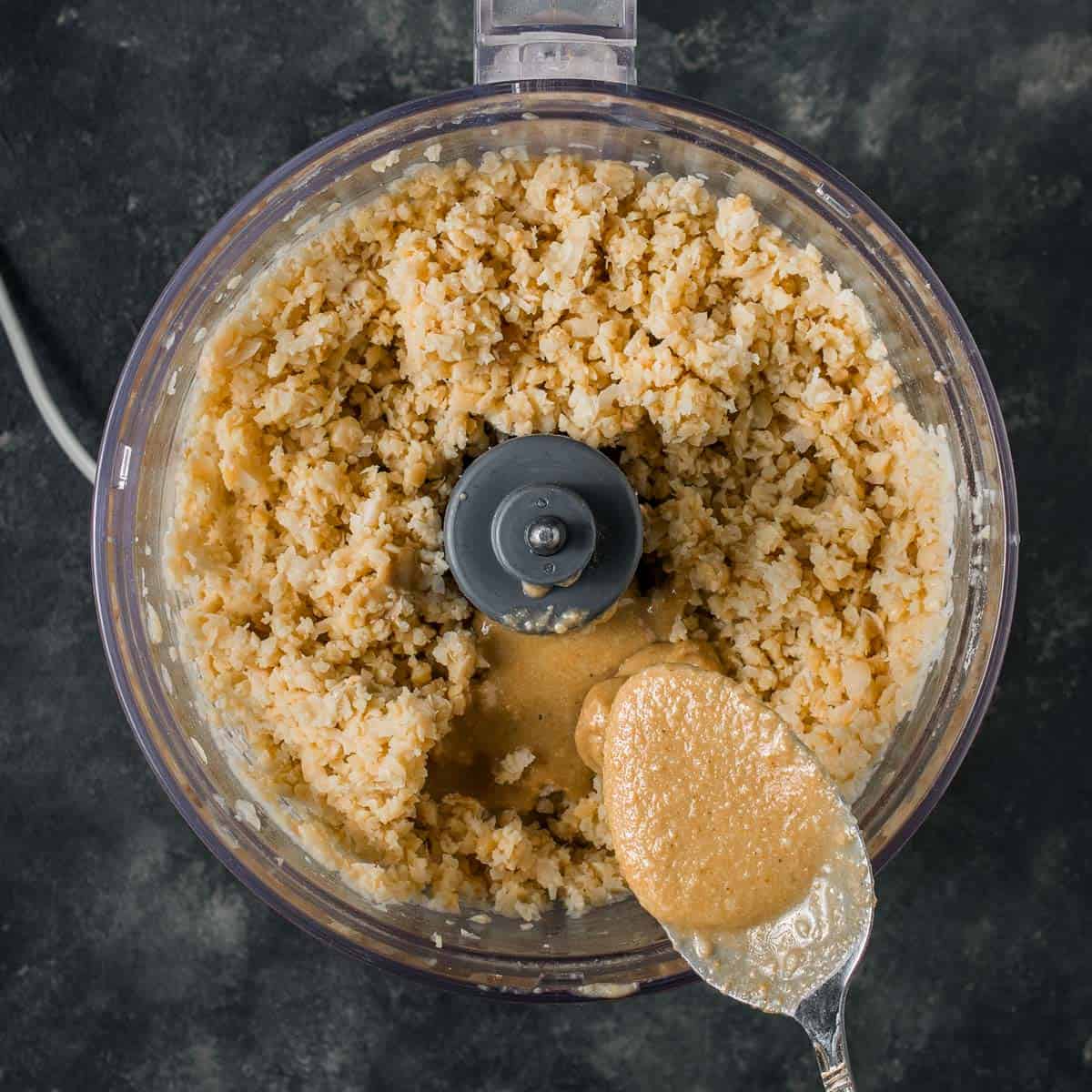 Blended chickpeas with tahini sauce in a food processor.