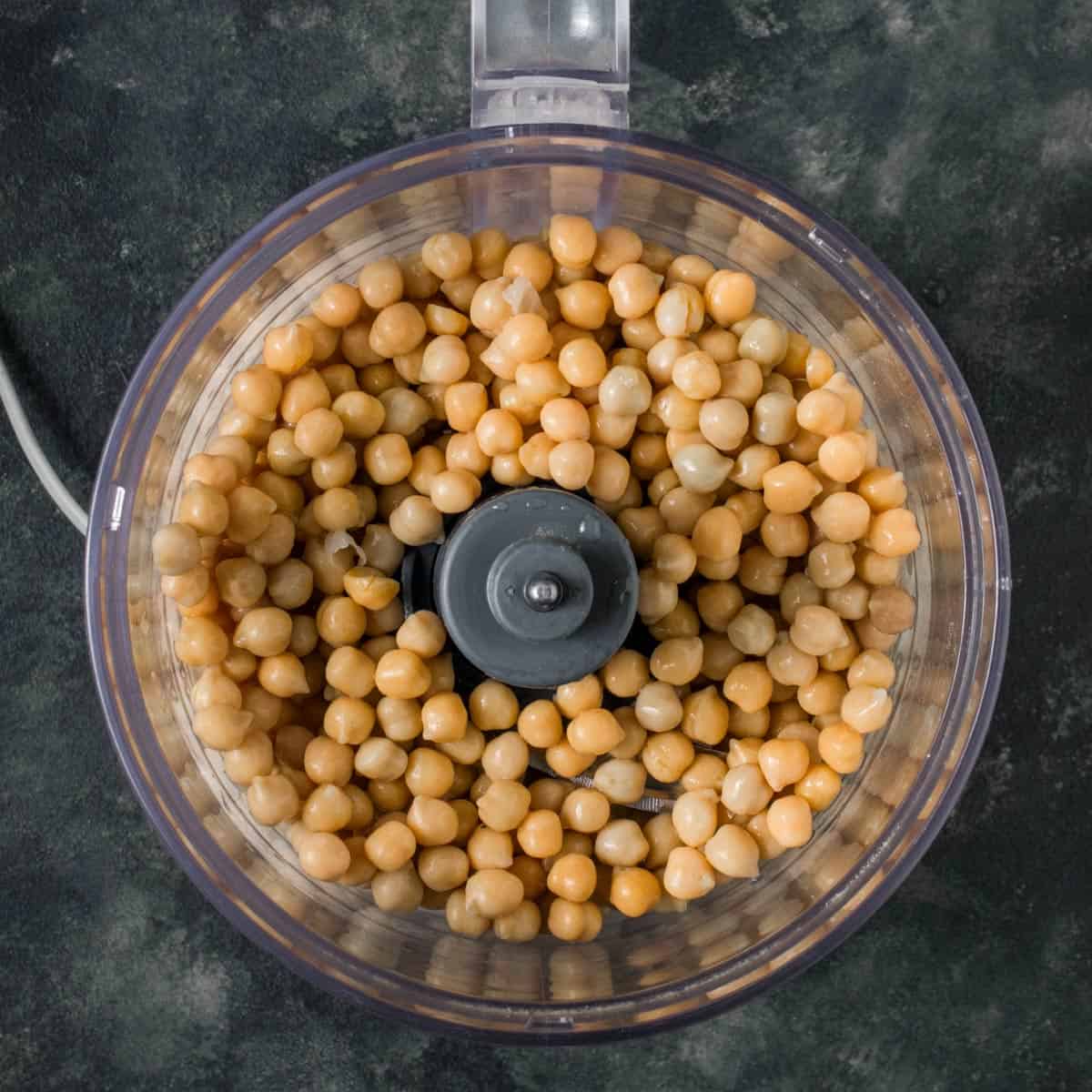 Drained canned chickpeas in a food processor. 