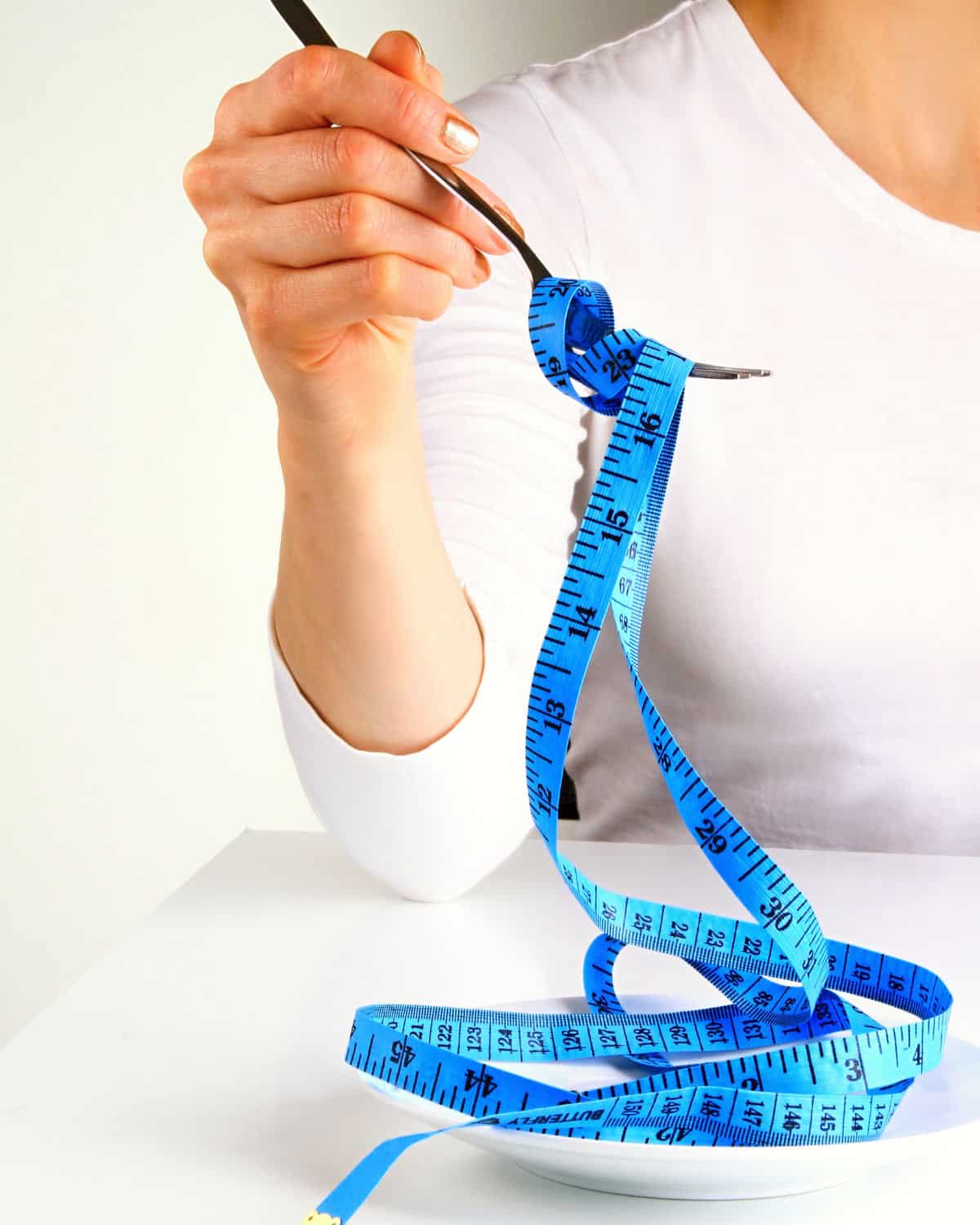 A person with a measuring tape on a fork.