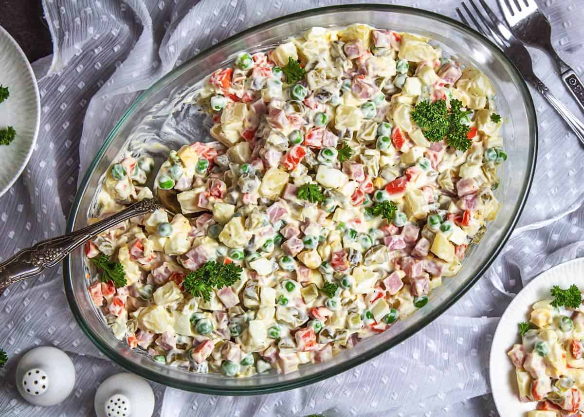 Russian salad on the table in an oval dish ready for serving.