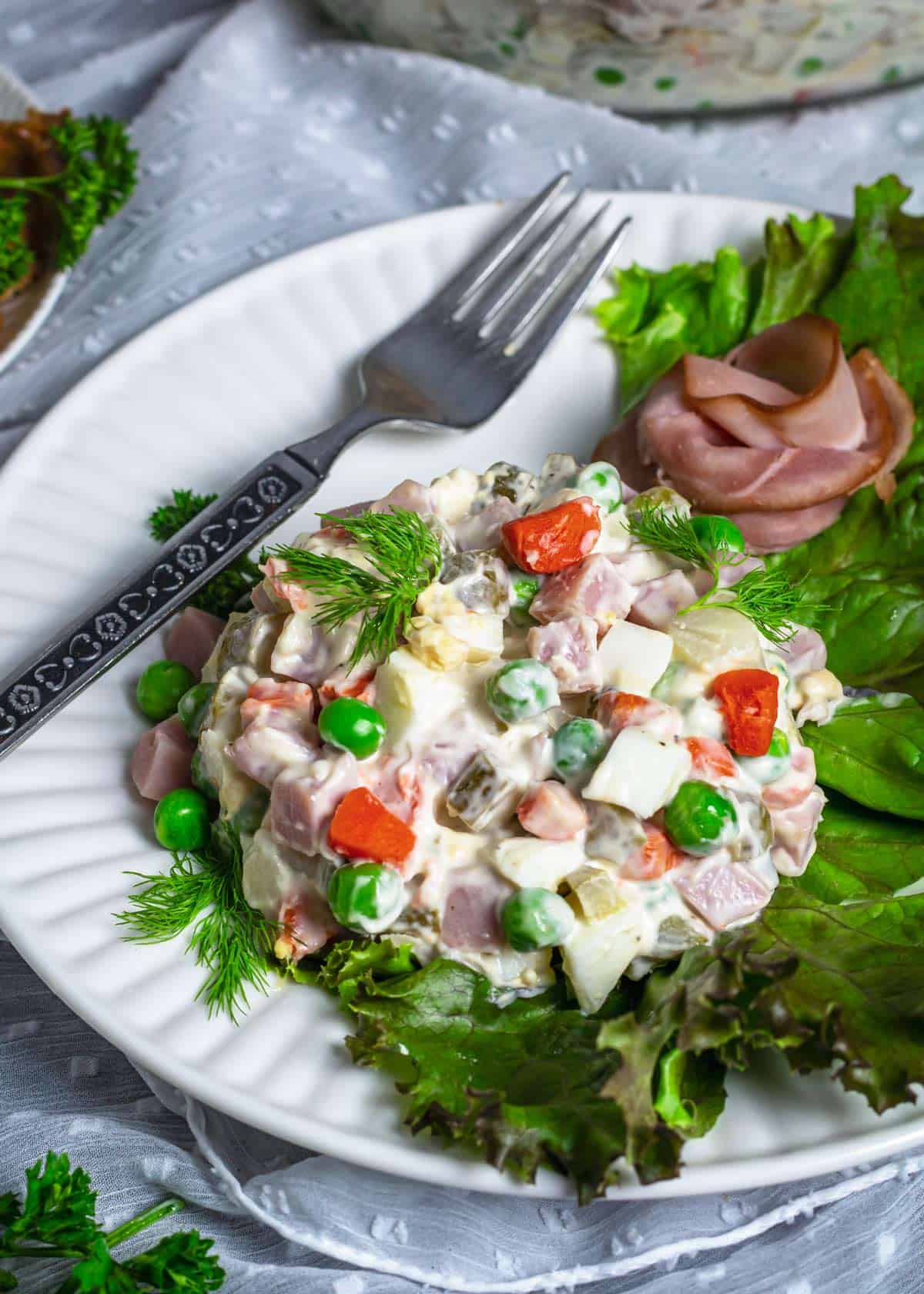 Olivier salad served on a white plate.